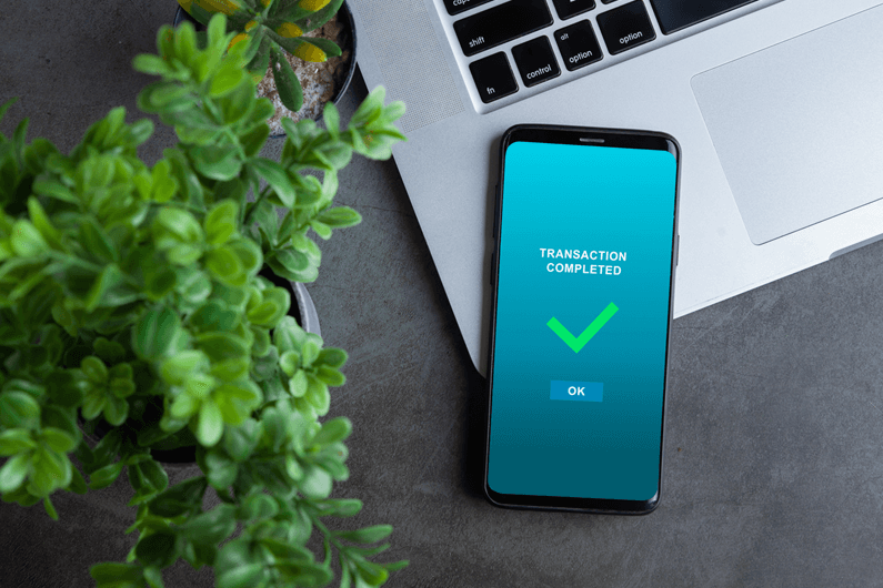 Cell phone showing a completed online transaction on the screen.